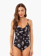 Traje de baño enterizo negro con estampado de motivos marinos en blanco, breteles finos y fruncido en la parte delantera.