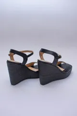 Sandalias de plataforma color lila con capellada de cuero y taco corrido cubierto de rafia.