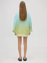 Cardigan tejido de punto con patrón de rombos en degradé de grises y blanco. Tiene corte oversize, mangas largas y cierre frontal con botones.