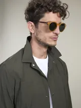 Camisa verde militar de manga larga con cierre de botones, cuello clásico y dos bolsillos frontales con solapa.