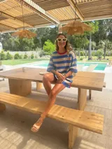 Remerón oversize de algodón a rayas horizontales azules y beige, con cuello redondo y ribete rojo.