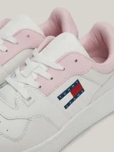 Zapatillas Tommy Jeans Essential de cuero blanco con detalles en rosa en el talón y en la lengüeta. Presentan el logo de la marca en el lateral y suela de goma. Inspiradas en los modelos de baloncesto, cuentan con elementos distintivos tonales y un detalle de ventilación en la punta que les aporta un aire deportivo retro.