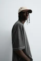 Camiseta color beige de corte holgado, cuello redondo y manga corta.