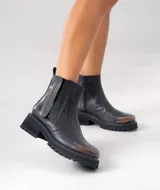 Botas Chelsea de cuero vacuno negro con elásticos laterales, cierre interno y suela de goma artesanal.