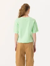 Remera rosa de algodón pima con estampado circular en el frente con la frase 'You Should Be Dancing' y un personaje bailando. Tiene corte amplio, mangas cortas, cuello redondo y tajos laterales.