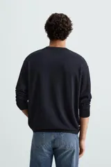 Jersey color topo de corte amplio, tejido en hilatura con mezcla de viscosa. Tiene cuello redondo, manga larga y terminaciones en rib.