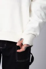 Buzo canguro negro de algodón friza, corte oversize y estampado de una rosa roja en el pecho.