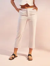 Pantalón color crema de corte recto, largo a la pantorrilla y confeccionado en lino.