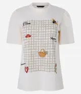 Remera blanca de corte slim con cuello redondo y mangas cortas abullonadas. Presenta un estampado frontal con diseño de picnic en tonos beige, con detalles bordados de abeja, cesta, hongo y texto en francés.