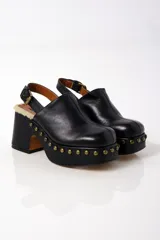 Zuecos de cuero negro adornados con tachuelas, con suela de plataforma y tacón de bloque grueso.