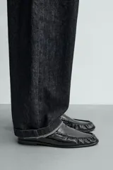 Mocasín de vestir negro con antifaz, de punta fina y suela a tono.