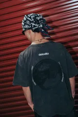Remera negra de algodón con estampa circular en la espalda con el logo de la marca y la inscripción 'Two Worlds One Mood'.