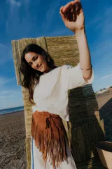 Cinturón marrón de gamuza con flecos largos y cierre con lazos.