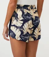 Short runner de viscosa con estampado de hojas en tonos beige y negro. Tiene cintura elástica con cordón ajustable, dos bolsillos laterales y dobladillo redondeado.