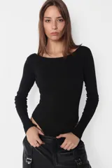 Campera puffer negra de cuero sintético, con cuello alto, cierre frontal con cremallera y bolsillos laterales.