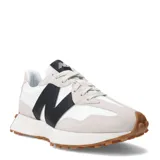 Championes urbanos New Balance modelo 327, color blanco con detalles en negro y suela marrón, confeccionados en gamuza y nylon, con logo "N" característico en los laterales y entresuela acolchada.