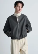Chaqueta bomber verde oliva de lana con cierre frontal con cremallera, cuello redondo, puños y bajo elásticos.