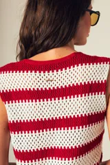 Top tejido a crochet con rayas horizontales blancas y negras, escote en V y cierre frontal con botones.