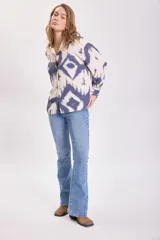 Camisa de manga larga con botones y cuello clásico, con estampado tie-dye en tonos azul y blanco.