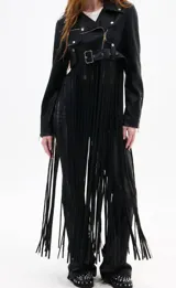 Campera corta negra estilo biker con cierre cruzado, cinturón con hebilla y flecos largos.