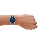 Reloj Emporio Armani modelo AR11571, con caja plateada de acero inoxidable de 42mm y esfera azul con acabado sunray. Tiene manecillas e índices plateados, ventana de fecha a las 3 en punto y correa de acero inoxidable plateada con cierre desplegable.