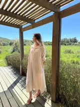 Vestido camisero amplio y largo de lino color azul, con botones de nácar, cuello camisero y bolsillos laterales.