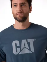 Remera de manga corta y cuello redondo, color azul grisáceo, con el logo de Caterpillar (CAT) estampado en el pecho en color gris claro.