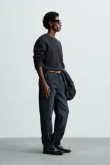 Camiseta blanca de manga larga con cuello redondo y textura cuadriculada.