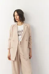 Blazer color beige de corte recto con solapas y cierre cruzado con cuatro botones.