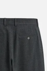 Pantalón slim fit negro confeccionado en tejido con elasticidad en ambas direcciones. Cuenta con bolsillos frontales y traseros de vivo con botón. Cierre frontal con cremallera y botón.
