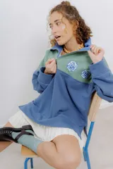 Buzo de algodón con cierre metálico y bordados de flores. Diseño color block en verde y azul.