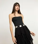 Cinturón de metal plateado con argollas y rodelas.