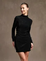 Minivestido negro de cuello alto y manga larga, con frunces y lazos laterales.