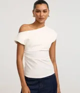 Blusa de crepé color blanco, con escote asimétrico, manga corta y drapeado lateral.