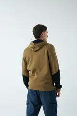 Campera marrón de felpa con capucha, cierre frontal y bolsillos laterales con cierre. Presenta mangas largas negras y logo de la marca estampado en el pecho.