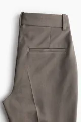 Pantalón tobillero ajustado de vestir color gris topo, con cintura estándar con elástico oculto, cierre con corchete oculto, bolsillos al bies, bolsillos traseros decorativos y piernas ajustadas.