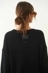 Sweater tejido color crudo, de manga larga con efecto desgastado y deshilachado en el ruedo y puños. Tiene cuello redondo y calce holgado.