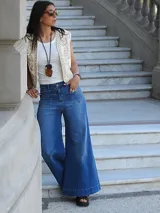 Pantalón de jean azul de corte pata elefante, tiro medio y confeccionado en denim con lycra.