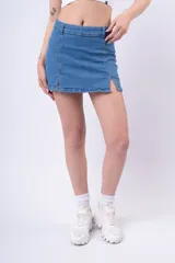 Minifalda de jean azul claro, tiro bajo, con aberturas frontales en el ruedo.