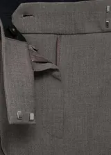 Pantalón de vestir color gris topo, de corte wide leg, tiro alto, con trabillas, cierre frontal con botón, gancho y cremallera, detalle de pinzas y dos bolsillos laterales.