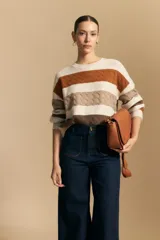 Jean de corte wide leg y tiro alto, color negro con costuras en contraste color ocre. Presenta bolsillos delanteros y traseros con detalle de pespunte, y ruedo ancho con costura decorativa.