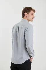 Camisa sport de corte clásico en color azul, con botones frontales y bolsillo en el pecho.