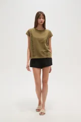 Remera blanca de algodón con apliques de encaje en los hombros, corte holgado y cuello redondo.