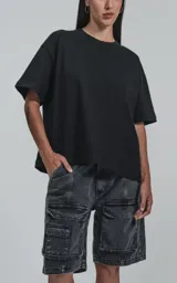 Bermuda de denim negro con efecto lavado, calce oversize, estilo cargo y múltiples bolsillos.