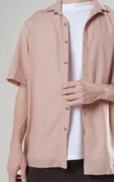 Camisa color beige de manga corta con calce oversize y canesú en la espalda.