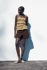 Shorts de jean blancos, tiro medio, corte mom fit, con cinco bolsillos y cierre frontal con cremallera y botón.