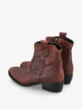 Botín de cuero negro de estilo texano con punta fina y costuras decorativas.