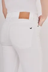 Pantalón jean blanco de corte slim, tiro alto y terminación desflecada en el ruedo.