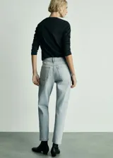 Pantalón de jean celeste, tiro alto, corte mom fit, con cinco bolsillos, cierre de cremallera y botón.