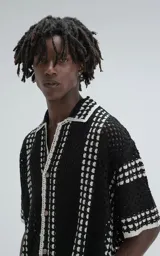 Camisa de manga corta tejida a crochet, color negro con detalles en blanco, de corte oversize.